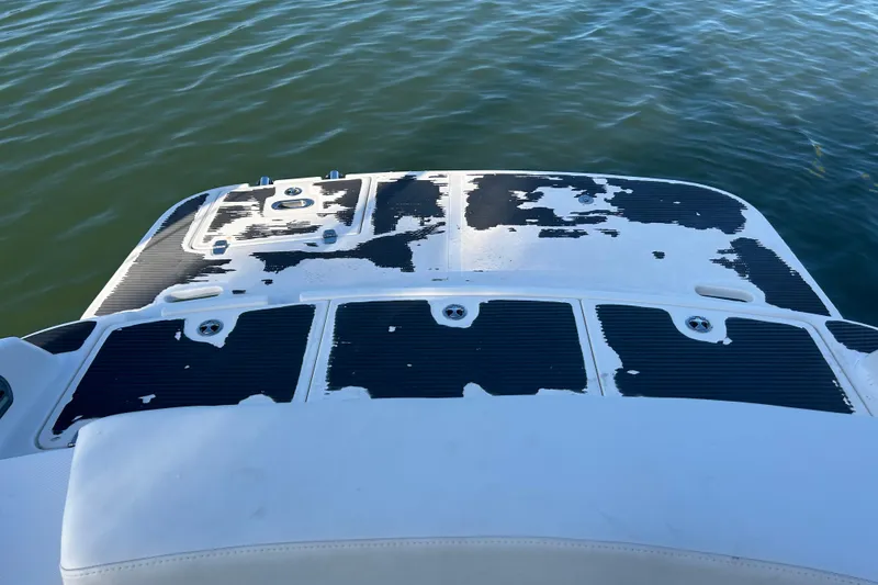 Slide: The Image of 2009 Regal 2400 Bowrider swim platform with worn black and white surface, on calm water. - 69