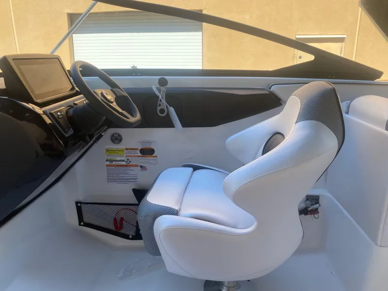 Slide: The Image of Interior of 2025 Scarab 255 ID boat with white captain's chair and dashboard. - 16