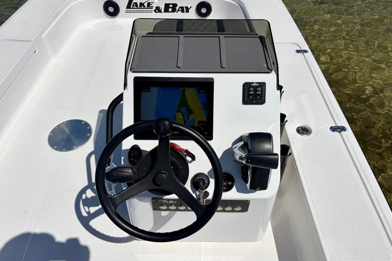 Slide: The Image of 2024 Lake & Bay Boca Grande 21 boat console with steering wheel and navigation display. - 14