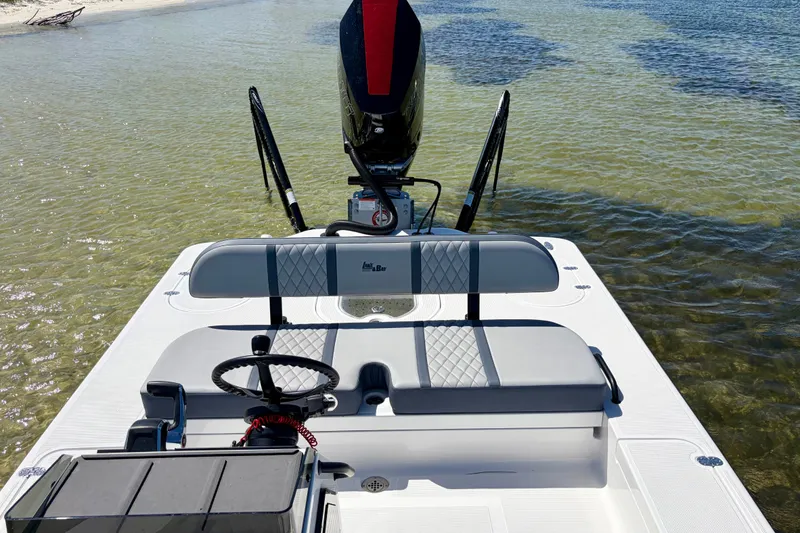 Slide: The Image of 2024 Lake & Bay Boca Grande 21 boat interior with steering wheel, seating, and water view. - 13