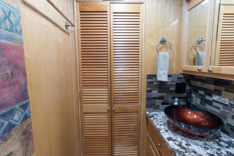 Slide: The Image of 2001 Stardust Cruisers Executive Aft Cabin bathroom with vessel sink and wooden cabinetry. - 38