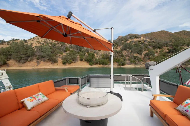Slide: The Image of Orange patio furniture on a 2001 Stardust Cruisers Executive Aft Cabin boat, with scenic lake view. - 57