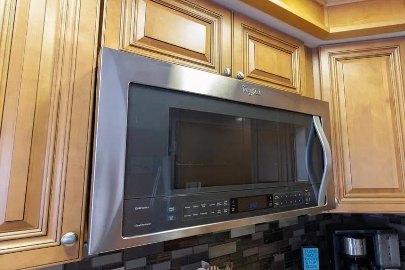 Slide: The Image of Stainless steel microwave installed in wooden kitchen cabinetry, featuring digital controls. - 15