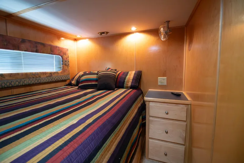 Slide: The Image of Cozy bedroom in 2001 Stardust Cruisers Executive Aft Cabin with striped bedding and wooden decor. - 27