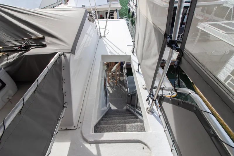 Slide: The Image of Stardust Cruisers 2001 Executive Aft Cabin, stairway view with covered deck and marina backdrop. - 64