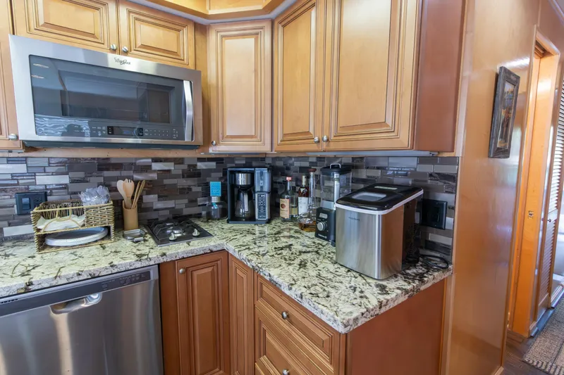 Slide: The Image of Kitchen area in 2001 Stardust Cruisers Executive Aft Cabin with modern appliances and granite countertops. - 23