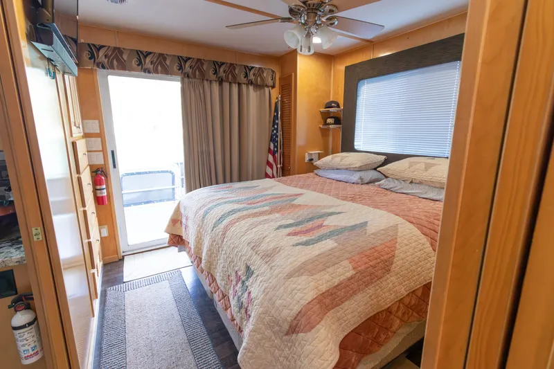 Slide: The Image of Cozy bedroom in 2001 Stardust Cruisers Executive Aft Cabin with quilted bedspread and ceiling fan. - 42