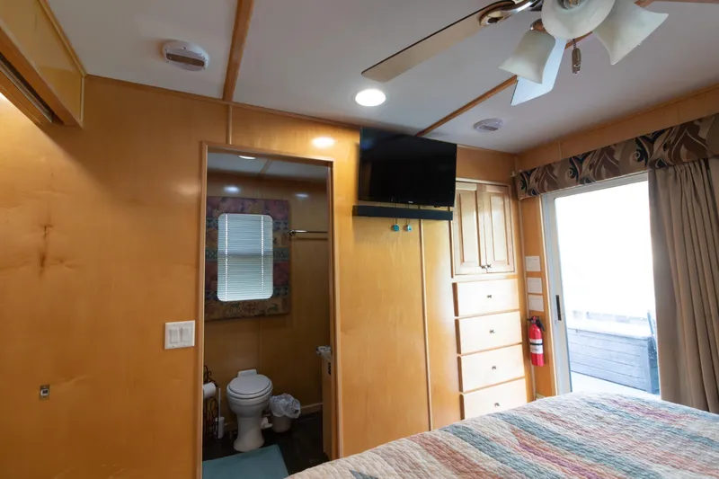 Slide: The Image of 2001 Stardust Cruisers Executive Aft Cabin interior with bathroom, TV, and storage. - 45
