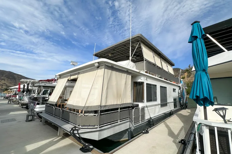 Slide: The Image of 2001 Stardust Cruisers Executive Aft Cabin houseboat docked under a clear blue sky. - 2