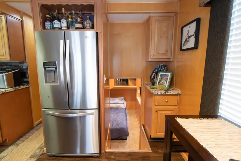 Slide: The Image of 2001 Stardust Cruisers Executive Aft Cabin interior with fridge, cabinets, and cozy sleeping area. - 18