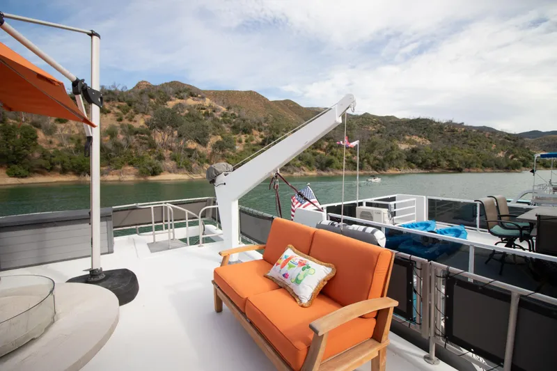 Slide: The Image of 2001 Stardust Cruisers Executive Aft Cabin with orange seating on deck, scenic lake view. - 58