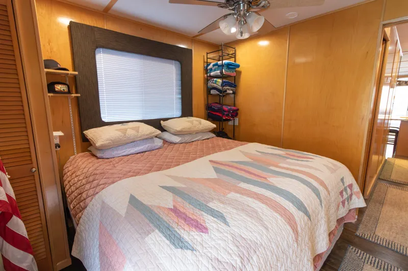 Slide: The Image of Cozy bedroom in 2001 Stardust Cruisers Executive Aft Cabin with quilted bedspread and wooden walls. - 44