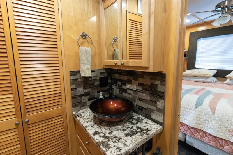 Slide: The Image of Luxurious 2001 Stardust Cruisers Executive Aft Cabin bathroom with vessel sink and cozy bedroom view. - 37