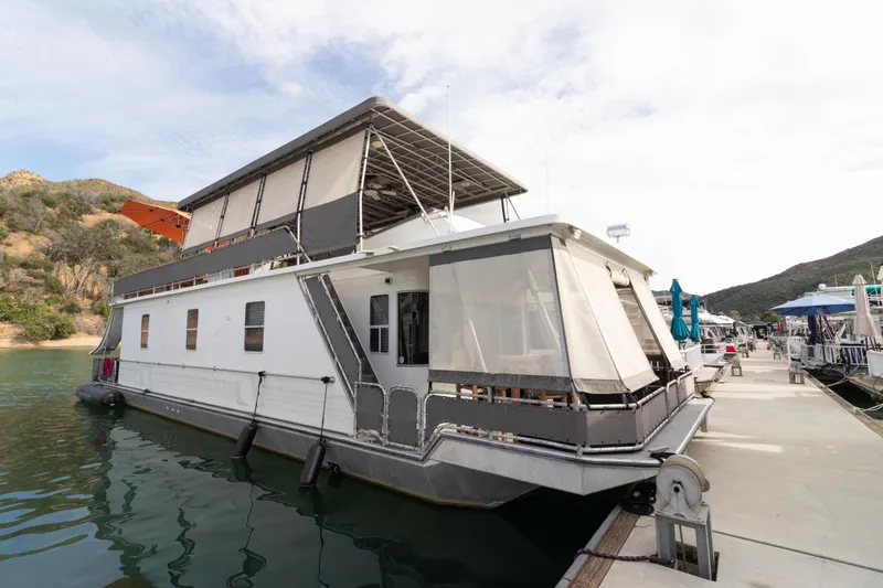 Slide: The Image of 2001 Stardust Cruisers Executive Aft Cabin houseboat docked on a serene lake. - 68