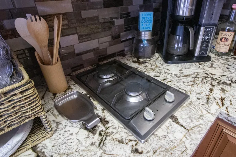 Slide: The Image of Kitchen countertop with stove, coffee maker, and utensils on a 2001 Stardust Cruisers Executive Aft Cabin. - 14