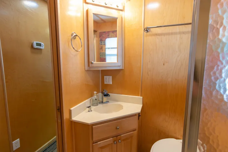 Slide: The Image of Bathroom interior of 2001 Stardust Cruisers Executive Aft Cabin with wooden cabinetry and modern fixtures. - 33