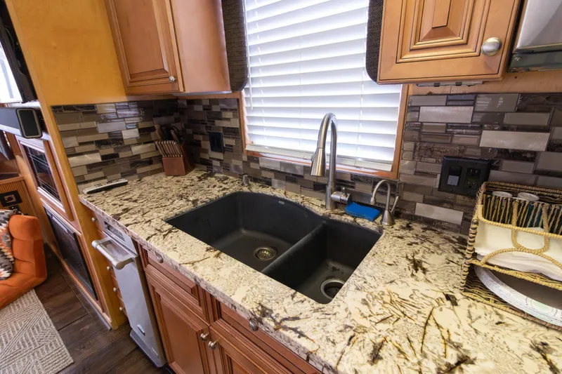 Slide: The Image of Luxurious kitchen sink area in 2001 Stardust Cruisers Executive Aft Cabin with granite countertops. - 13