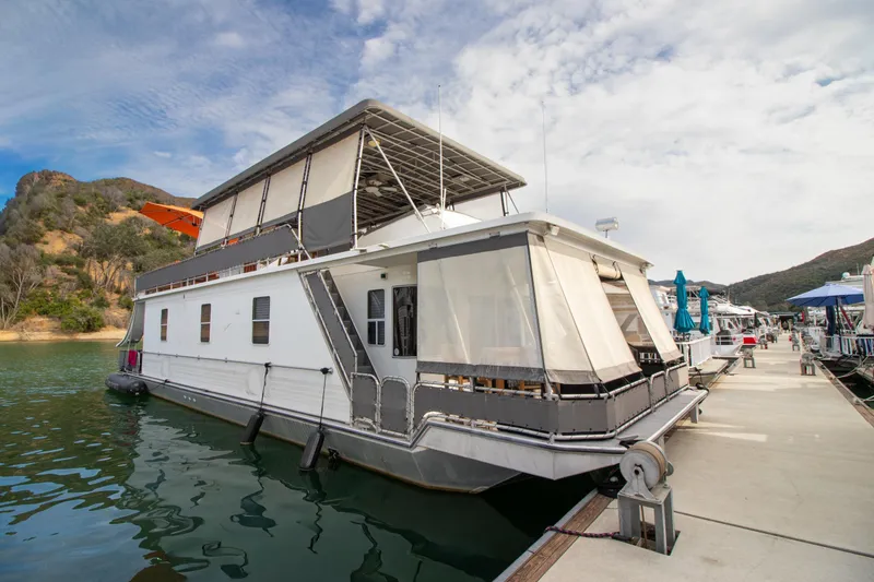 Slide: The Image of 2001 Stardust Cruisers Executive Aft Cabin houseboat docked on a scenic lake. - 1