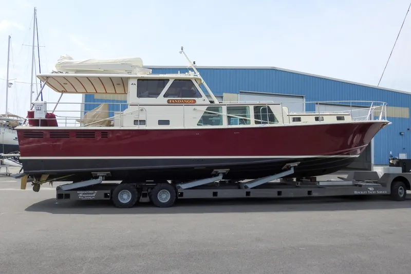 Slide: The Image of 2012 Dettling Motoryacht on trailer, red hull, docked at marina. - 6
