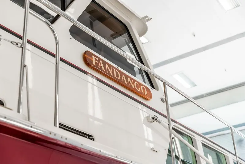 Slide: The Image of 2012 Dettling Motoryacht "Fandango" with sleek white and red design in a bright setting. - 10