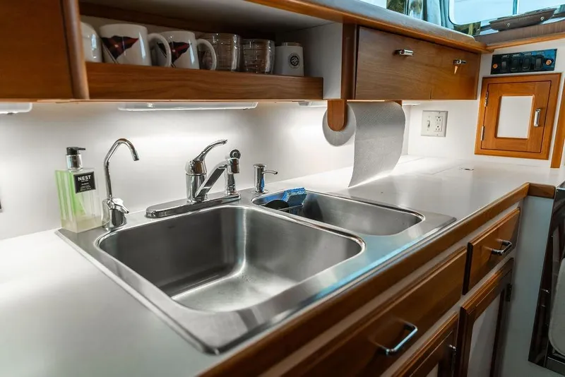 Slide: The Image of Modern kitchen sink area on a 2012 Dettling Motoryacht with wooden cabinetry. - 28