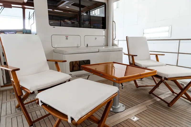 Slide: The Image of Luxurious 2012 Dettling Motoryacht deck with elegant wooden furniture and cushioned seating. - 4