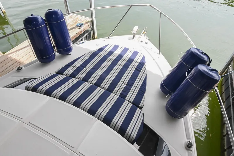 Slide: The Image of 2009 Regal 3060 Window Express boat with striped cushions and blue fenders on deck. - 26