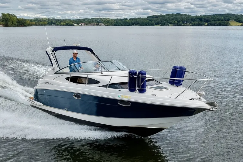 The Image of 2009 Regal 3060 Window Express cruising on a serene lake under cloudy skies. - 0
