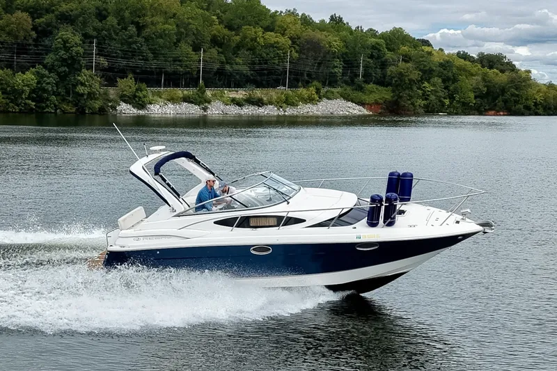 Slide: The Image of 2009 Regal 3060 Window Express cruising on a scenic lake with lush green shoreline. - 4