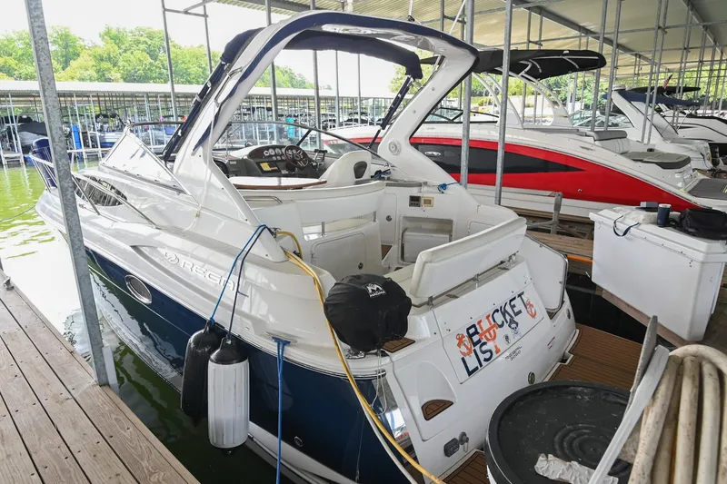 Slide: The Image of 2009 Regal 3060 Window Express boat docked in a marina, featuring sleek design and spacious interior. - 3
