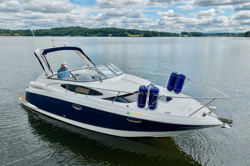 Slide: The Image of 2009 Regal 3060 Window Express boat on a serene lake under a cloudy sky. - 62