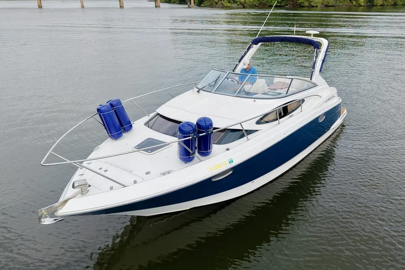 Slide: The Image of 2009 Regal 3060 Window Express boat on calm water, featuring blue and white design. - 63