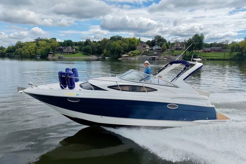 Slide: The Image of 2009 Regal 3060 Window Express cruising on a scenic lake under a cloudy sky. - 1