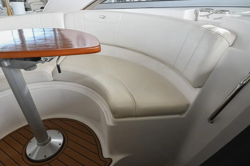 Slide: The Image of 2009 Regal 3060 Window Express boat interior with curved seating and wooden table. - 17