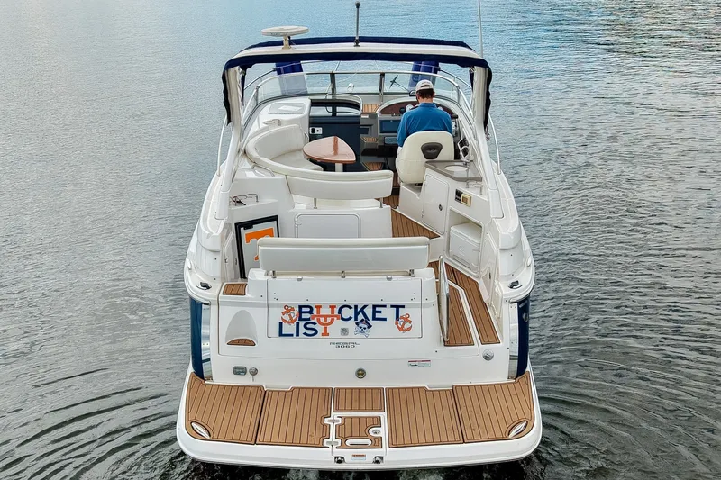 Slide: The Image of 2009 Regal 3060 Window Express boat on water, rear view with "Bucket List" sign. - 5