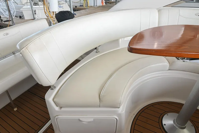 Slide: The Image of 2009 Regal 3060 Window Express boat interior with curved white seating and wooden table. - 16