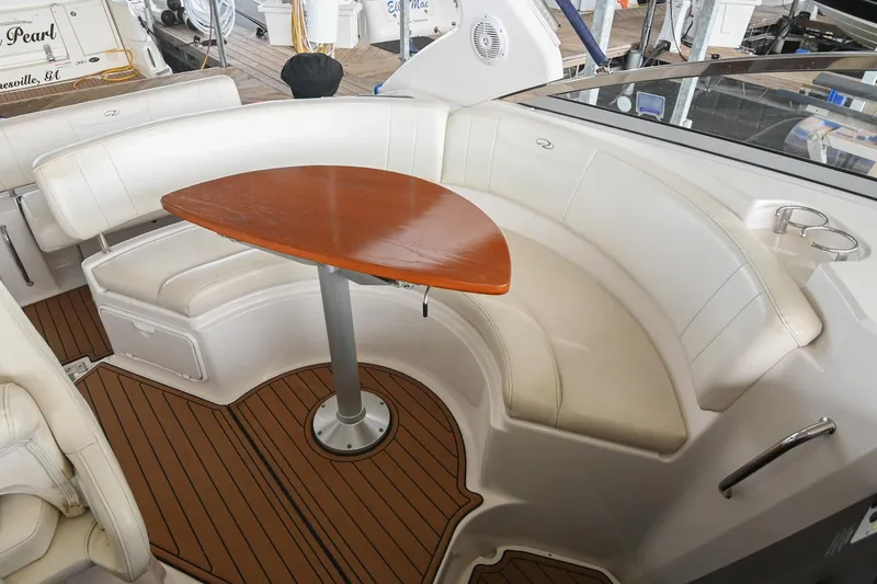 Slide: The Image of 2009 Regal 3060 Window Express boat interior with curved seating and wooden table. - 15