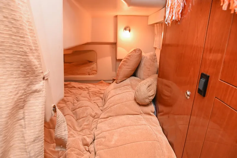 Slide: The Image of Cozy cabin interior of 2009 Regal 3060 Window Express with warm lighting and plush bedding. - 45