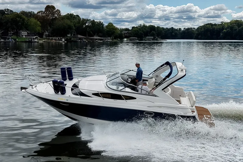 Slide: The Image of 2009 Regal 3060 Window Express cruising on a serene lake under a cloudy sky. - 3