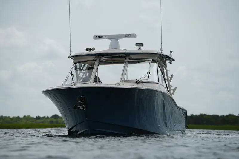 Slide: The Image of 2018 Grady-White Freedom 325 boat on calm water, front view with Garmin equipment. - 5
