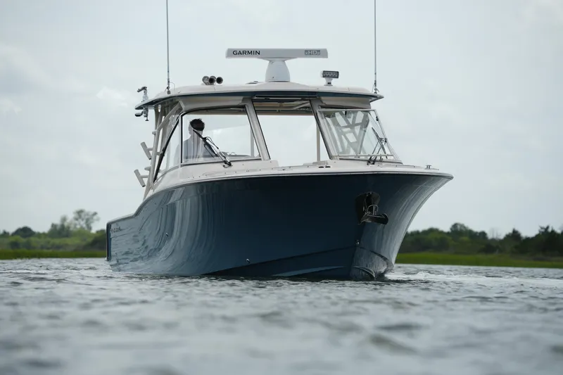 Slide: The Image of 2018 Grady-White Freedom 325 boat cruising on calm waters, front view. - 7
