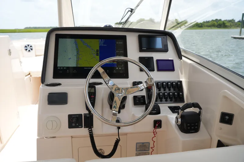 Slide: The Image of 2018 Grady-White Freedom 325 boat dashboard with navigation controls and steering wheel. - 33