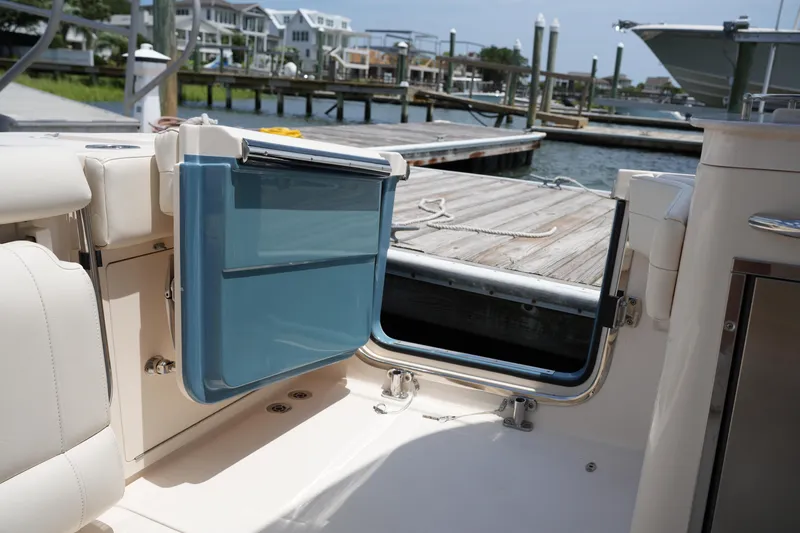 Slide: The Image of 2018 Grady-White Freedom 325 boat interior, featuring open transom door at dockside. - 21