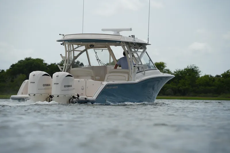 Slide: The Image of 2018 Grady-White Freedom 325 boat cruising on water with twin Yamaha engines. - 14