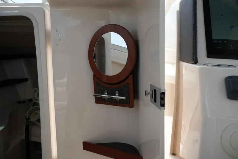 Slide: The Image of Interior of 2018 Grady-White Freedom 325 boat featuring a mirror and storage compartment. - 47