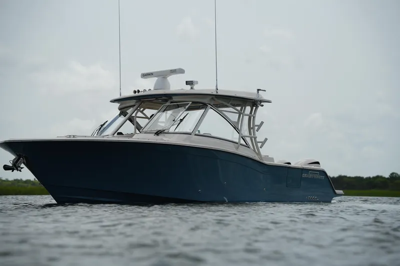 Slide: The Image of 2018 Grady-White Freedom 325 boat on calm water, showcasing sleek design and modern features. - 3