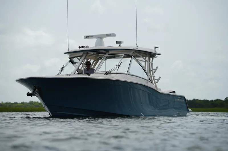 Slide: The Image of 2018 Grady-White Freedom 325 boat on water, showcasing sleek design and advanced features. - 4