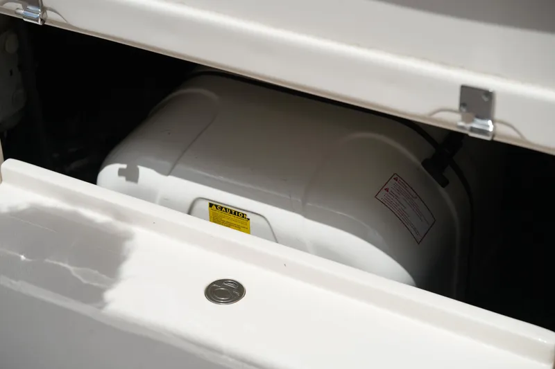 Slide: The Image of Storage compartment of 2018 Grady-White Freedom 325 boat, partially open with visible caution label. - 22