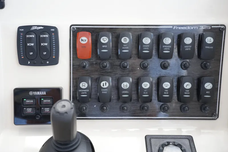 Slide: The Image of Control panel of 2018 Grady-White Freedom 325 boat with various switches and controls. - 40