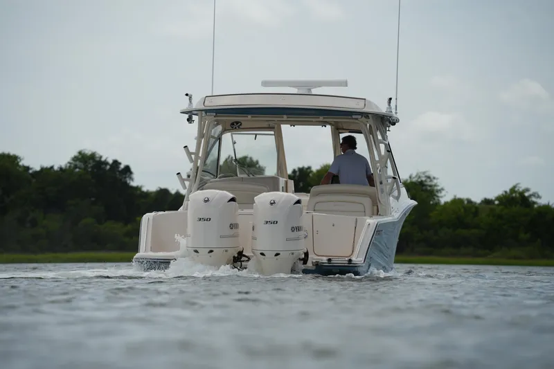 Slide: The Image of 2018 Grady-White Freedom 325 boat cruising on water with twin Yamaha 350 engines. - 15